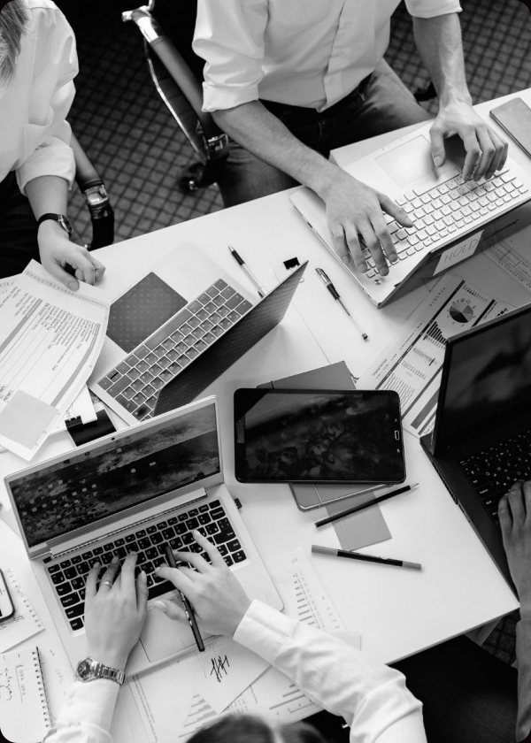 Equipa a trabalhar em portáteis à volta da mesma mesa